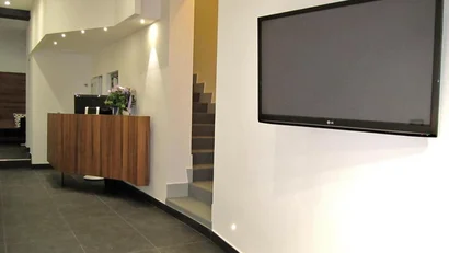 Ingresso moderno con TV a parete e mobile sospeso in legno