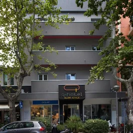 Facciata dell'hotel Glam Style con alberi e auto parcheggiate davanti